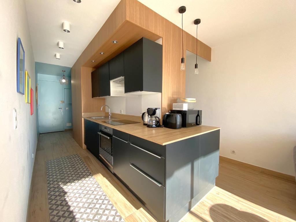 une cuisine avec un évier et un plan de travail dans l'établissement Appartement vue mer, au calme, proche de toutes commodités, à Fréjus