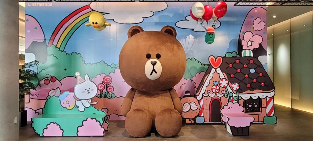 a large brown teddy bear sitting in front of a wall at Sotetsu Hotels The Splaisir Seoul Myeongdong in Seoul