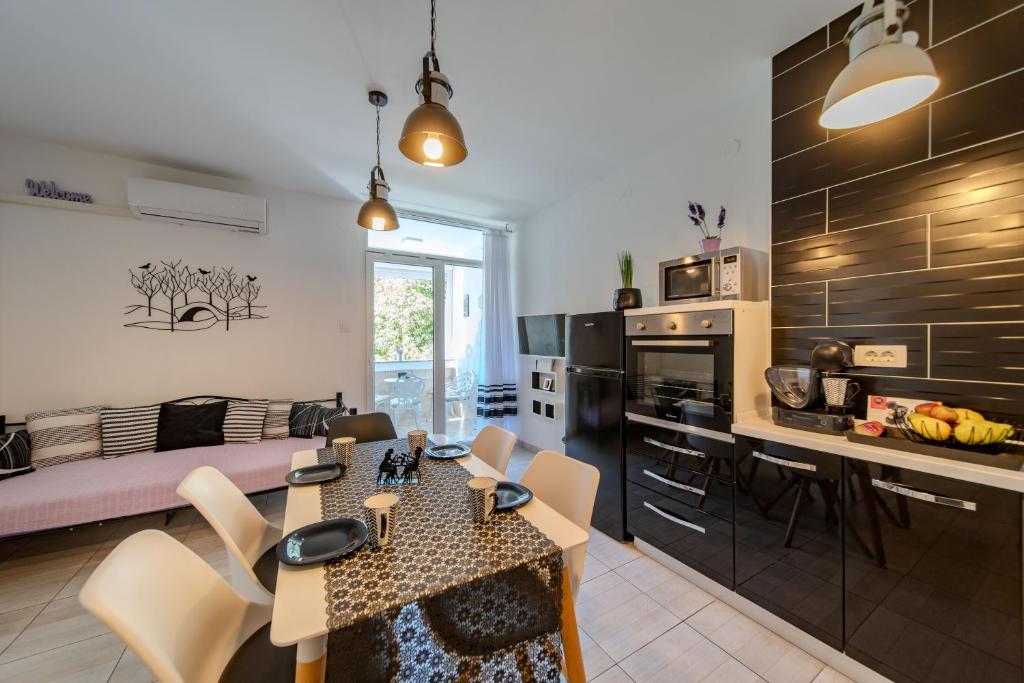 Una cocina y una sala de estar con mesa y sillas. en Rab centar, en Rab