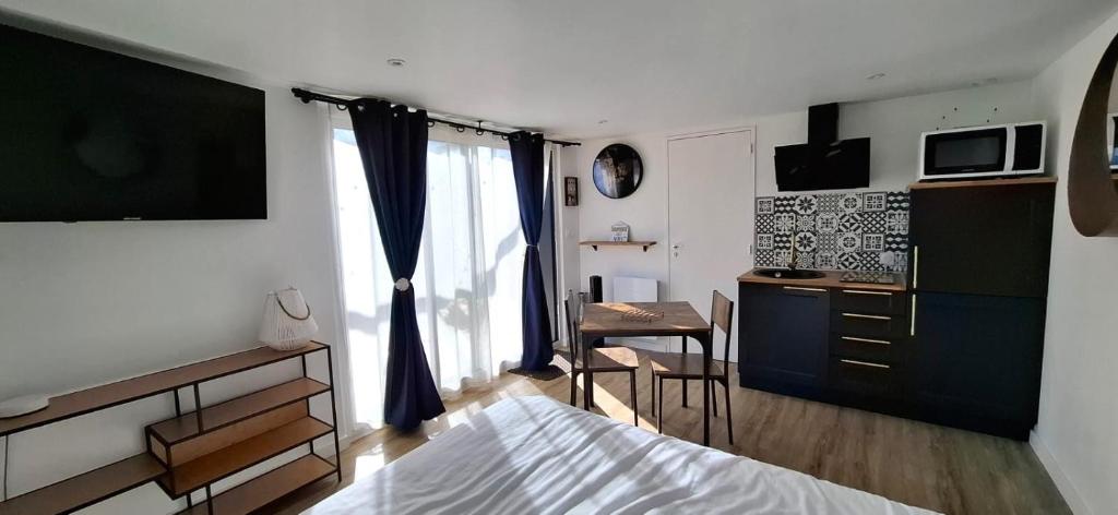 une chambre avec un lit et un bureau et une cuisine dans l'établissement Location Finistère Jaccuzi privé, à Plougourvest