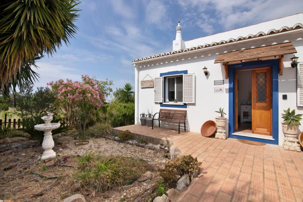 una piccola casa bianca con una porta in legno di Casa da Eira - Quinta do Mestre a Tavira