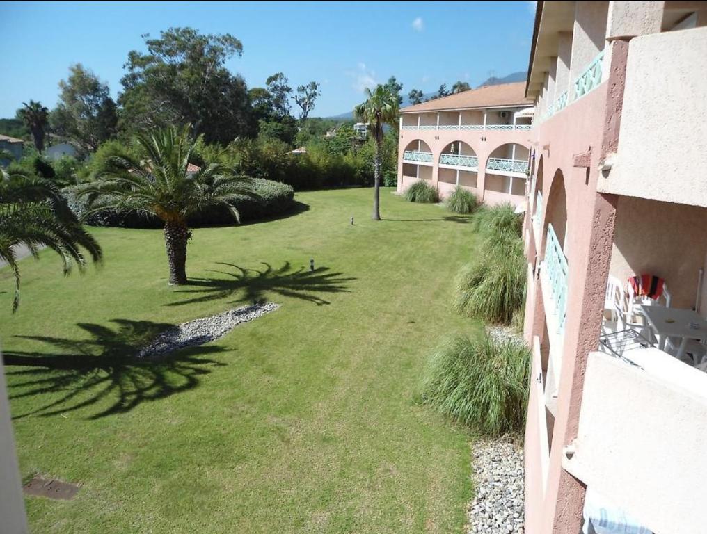 - une vue sur la cour depuis le balcon d'un bâtiment dans l'établissement Studio Cala Sognu Moriani residence, à San-Nicolao