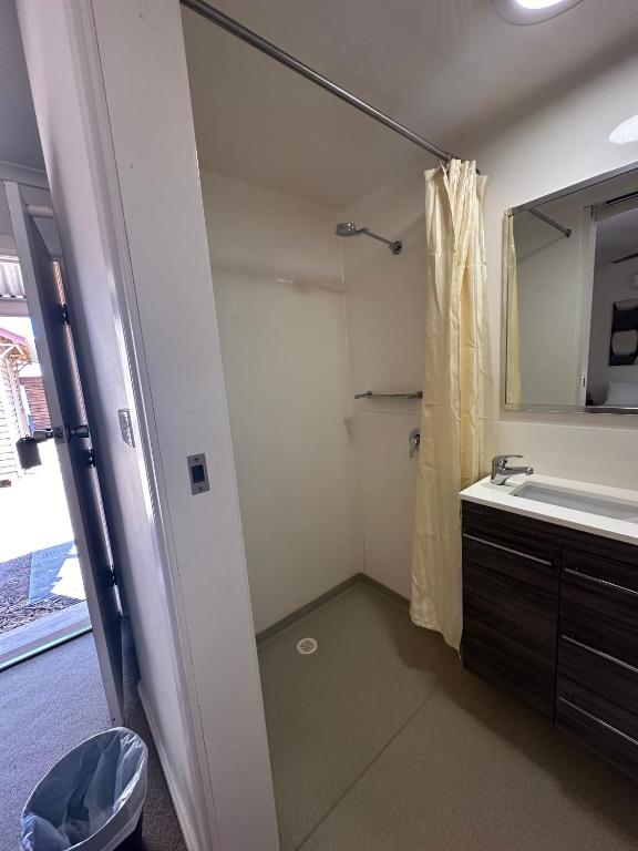 bagno con doccia, lavandino e specchio di Parachilna Overflow Accommodation a Flinders Ranges
