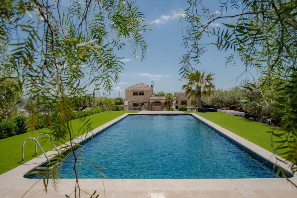 a swimming pool in the yard of a house at Villa Rural Avril in Camarles
