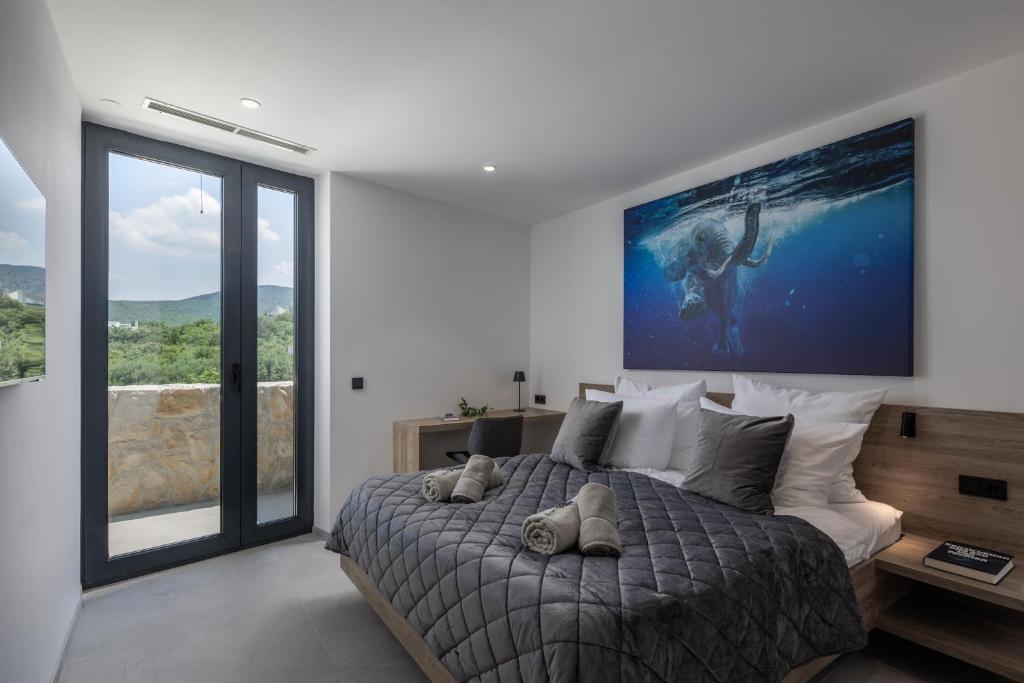 a bedroom with a bed with a large painting on the wall at Luxusvilla Moana mit Olivenhain in Vrbnik