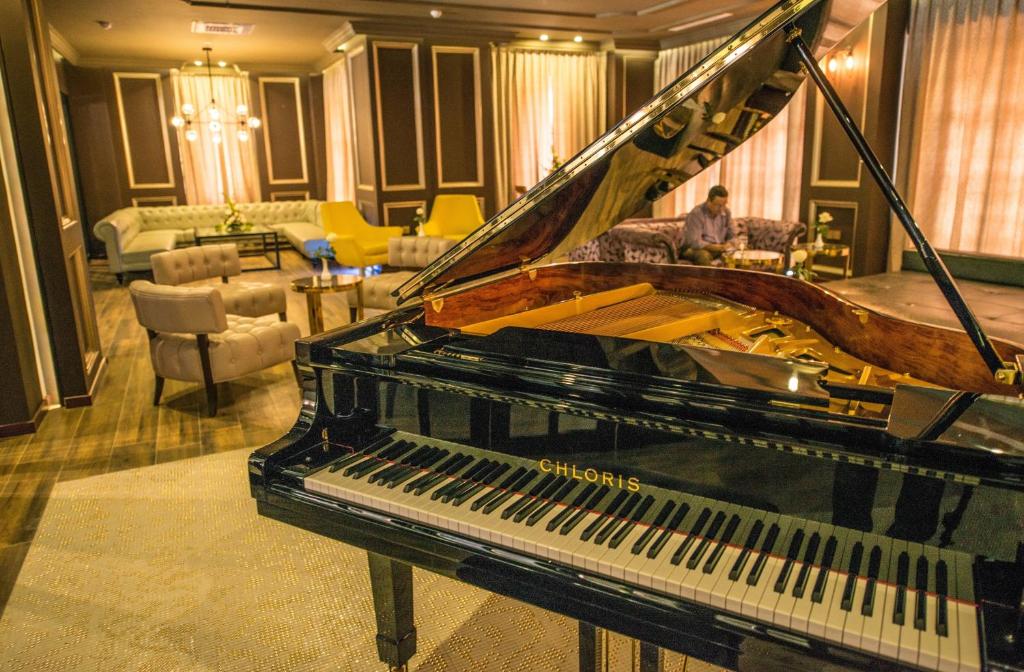 a piano in a room with a living room at Rose Garden Hotel in Yangon
