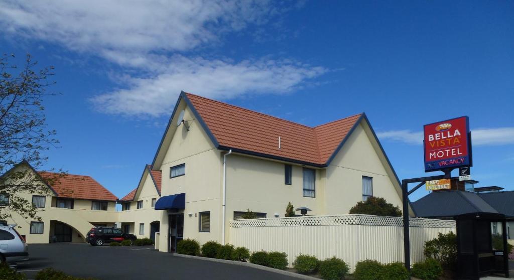 um grande edifício branco com um telhado vermelho em Bella Vista Motel Mosgiel em Mosgiel