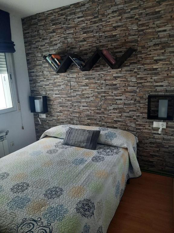a bedroom with a bed and a brick wall at Piso de La Luna in Cazorla