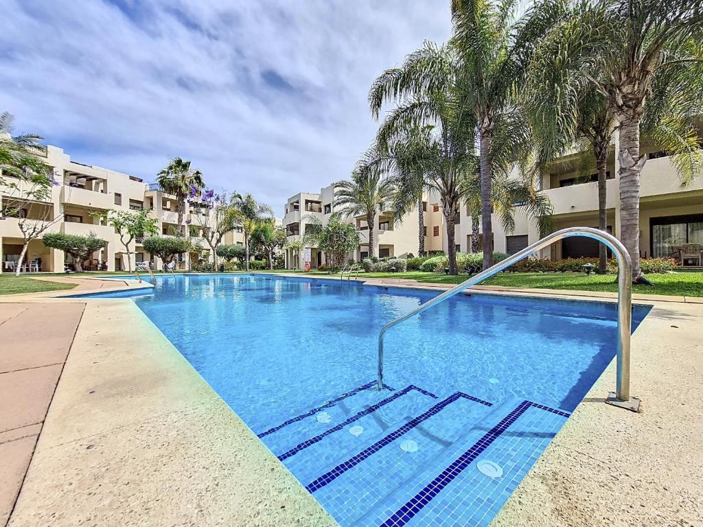 a large swimming pool with palm trees and condos at Roda Golf Resort - 4010 in Roda