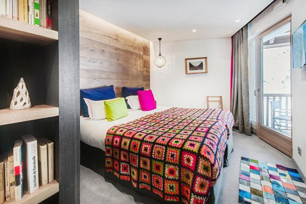 a bedroom with a bed with a colorful blanket at Hotel Pashmina Le Refuge in Val Thorens