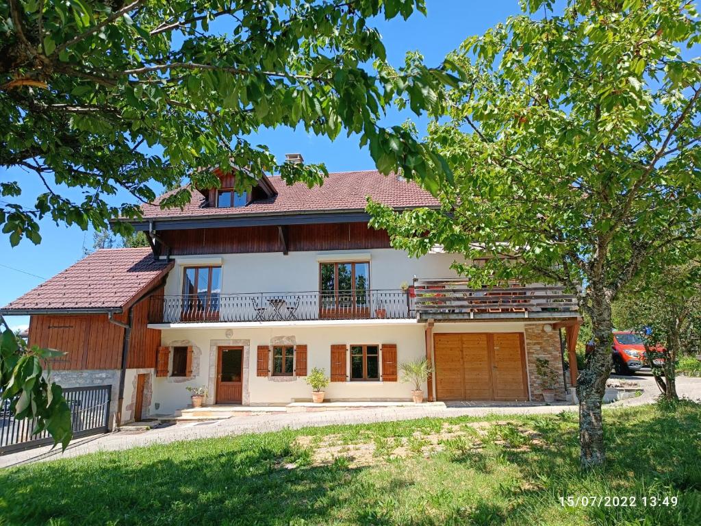 a large white house with a balcony at Gîte Cœur de Haute-Savoie in Viuz-en-Sallaz
