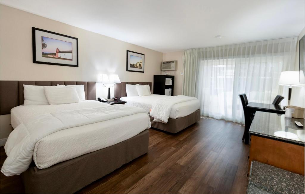 a hotel room with two beds and a desk at Pea Soup Andersen's Inn in Buellton