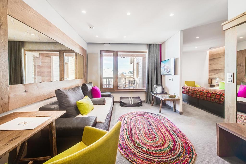 a living room with a couch and a table at Hotel Pashmina Le Refuge in Val Thorens