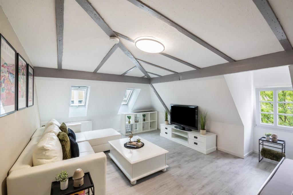 un salon avec un canapé blanc et une télévision dans l'établissement Am Röntgenmuseum, à Blume