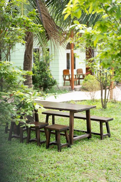 a picnic table and benches in the grass at B&H Villa - Villa has swimming pool in Lang Co