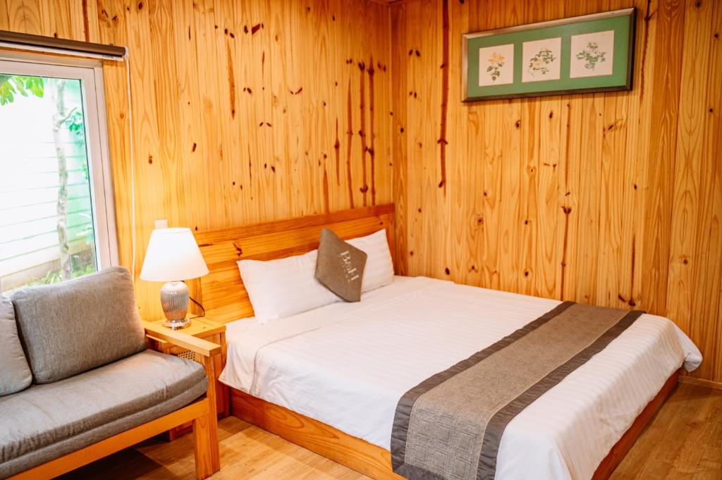 a bedroom with a bed and a chair and a window at B&H Villa - Villa has swimming pool in Lang Co