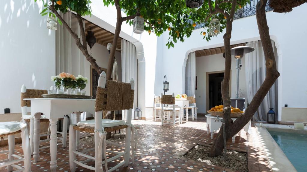 a patio with chairs and a table and a pool at Riad Les Orangers D'alilia in Marrakesh