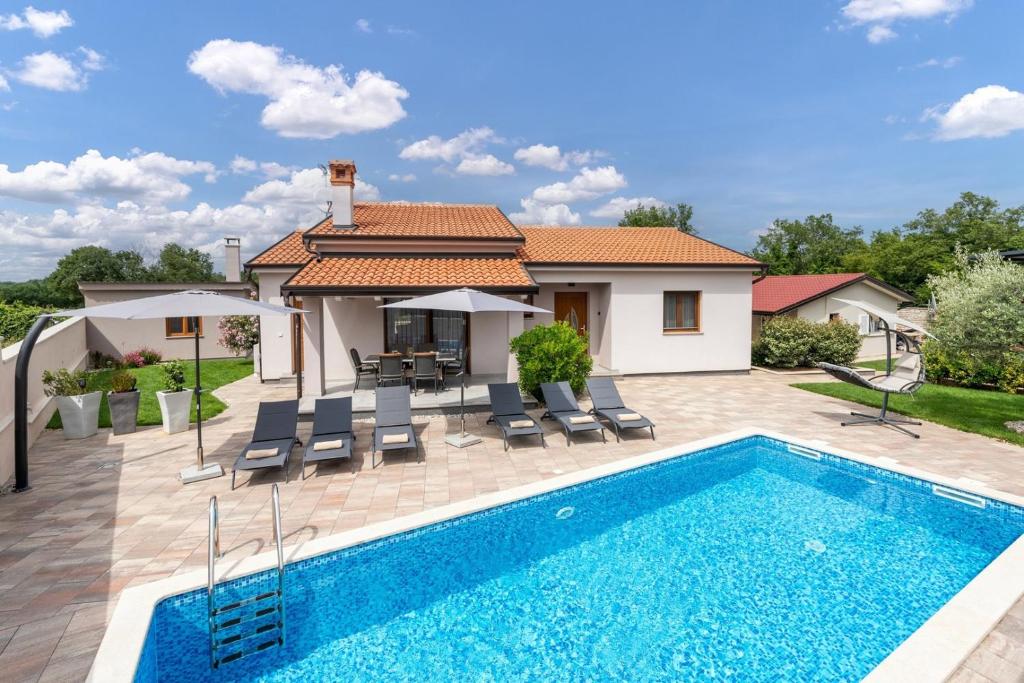 a villa with a swimming pool and a house at Villa Ajlin with Private Pool in Sveti Lovreč Pazenatički