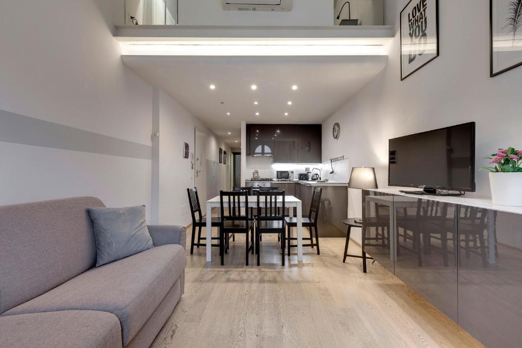 a living room with a couch and a table and a kitchen at San Zanobi Apartments by Mamo Florence in Florence
