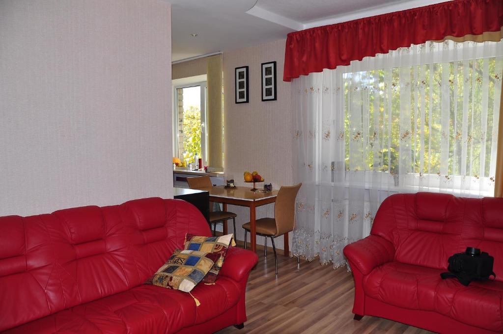 a living room with two red couches and a table at Central Cietokšņa Street Apartment in Daugavpils