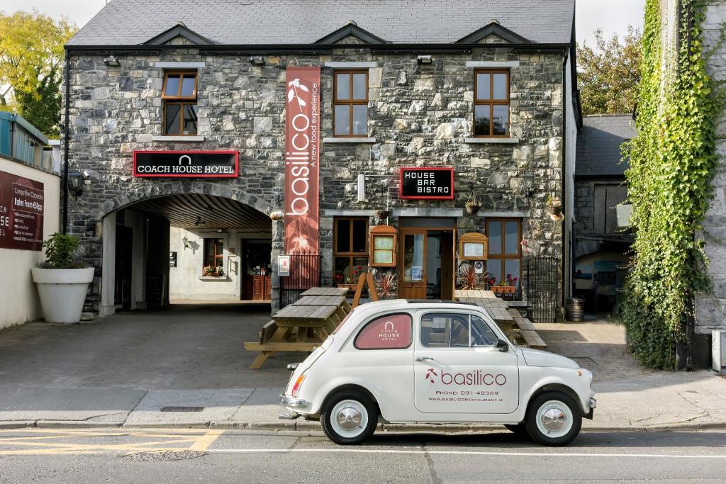 a small car parked in front of a building at The Coach House Hotel in Oranmore