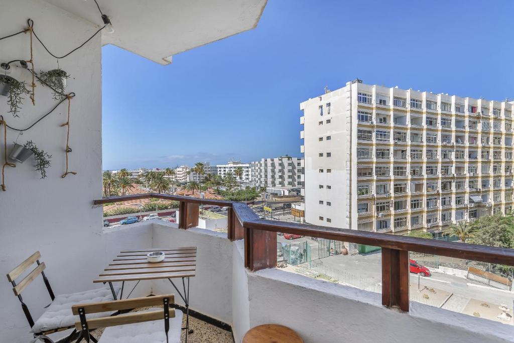 balcón con mesa y vistas a un edificio en Apartamento Con Encanto, en Maspalomas
