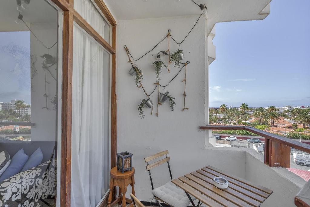 Habitación con balcón con mesa y ventana. en Apartamento Con Encanto, en Maspalomas