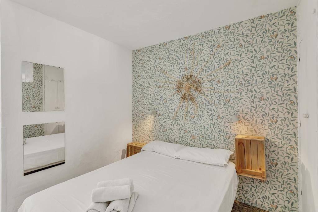 1 dormitorio con cama blanca y pared en Apartamento Con Encanto, en Maspalomas