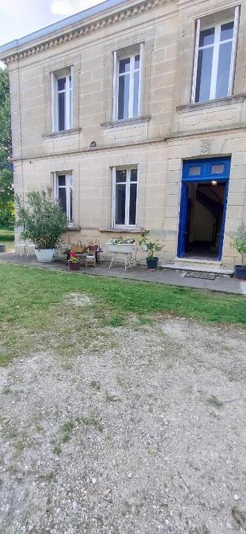 un bâtiment avec un banc devant lui dans l'établissement Chateau Monichot Organic Vineyard, à Tauriac