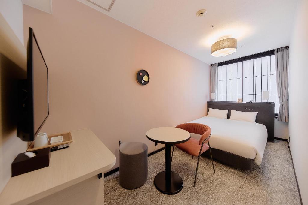 a hotel room with a bed and a table and a desk at Kyoto Tower Hotel in Kyoto