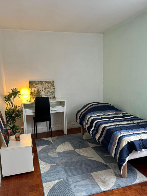 ein Schlafzimmer mit einem Bett und einem Schreibtisch in der Unterkunft Chambre équipée et meublée- Porte des Lilas in Paris