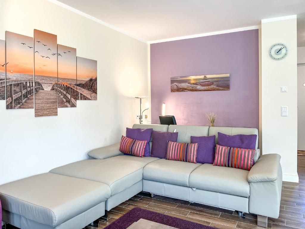 a living room with a couch and paintings on the wall at Reethaus Am Mariannenweg 18a in Boltenhagen