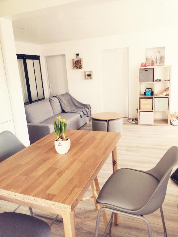 un salon avec une table et des chaises en bois dans l'établissement Magnifique T3, entre lac et montages, Embrun, à Embrun