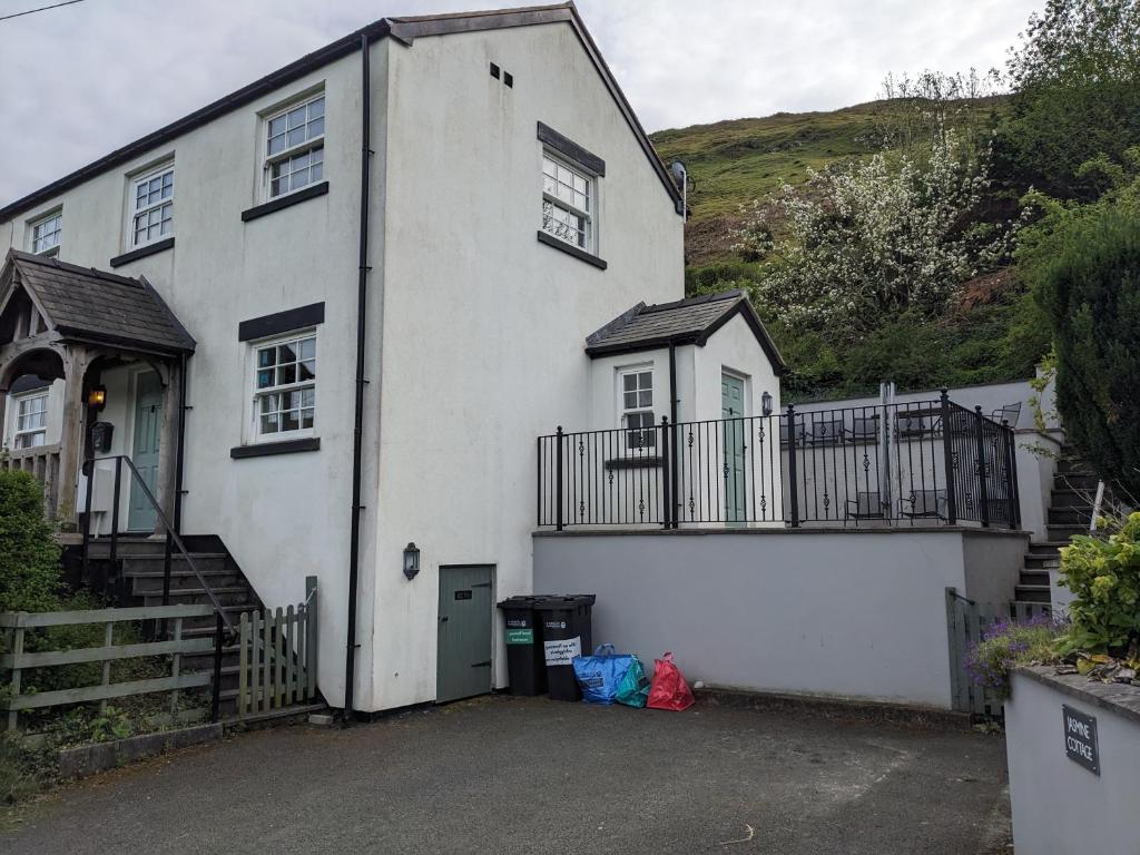 a white house with a balcony on the side of it at Jasmine Cottage in Llangollen