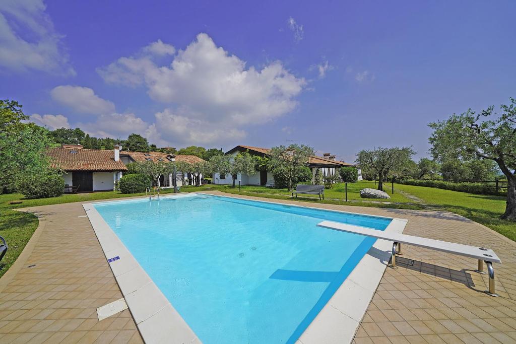 a large swimming pool in a yard with a house at Casa Felicita by Wonderful Italy in Soiano del Lago