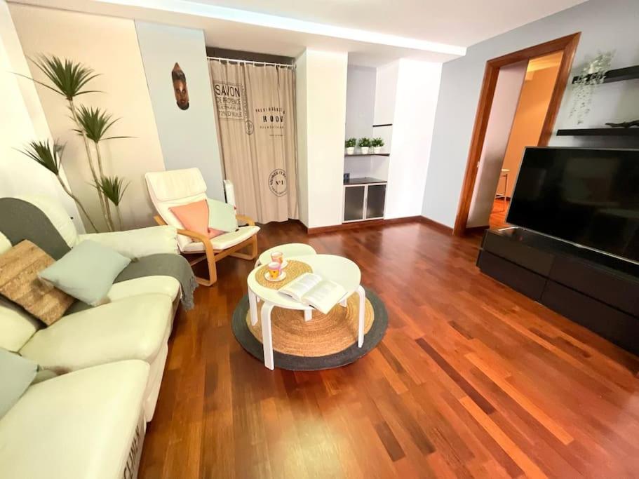 Una sala de estar con un sofá blanco y una mesa. en Casa de la lonja, en Fondón