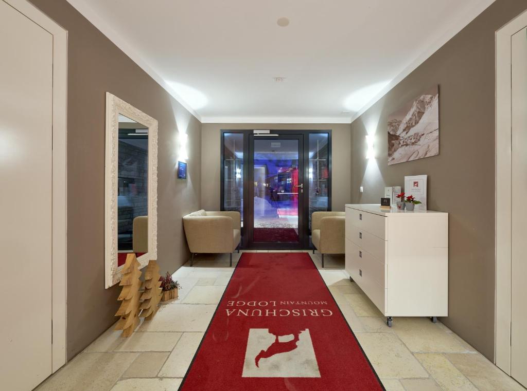 a hallway with a red rug on the floor at Grischuna Mountain Lodge in Samnaun