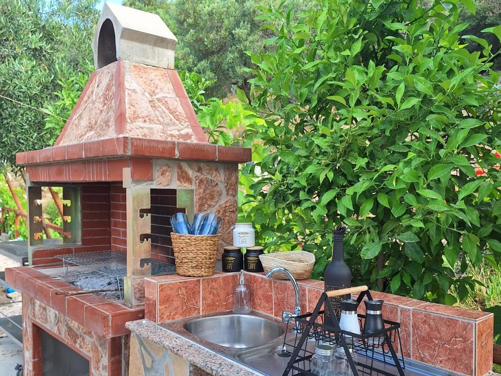 a outdoor kitchen with a sink and a brick oven at Sarti Thea in Sarti