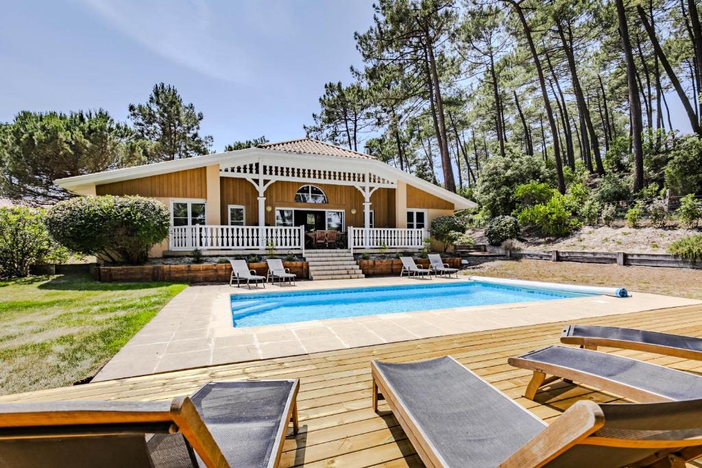 une maison avec une piscine et une maison dans l'établissement villa piscine 4ch dans la pinede a 4min de l ocean AG1, à Lacanau