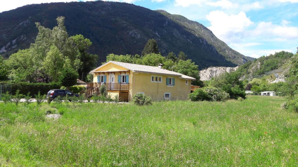 une maison dans un champ en face d'une montagne dans l'établissement Villa Castellane, à Castellane