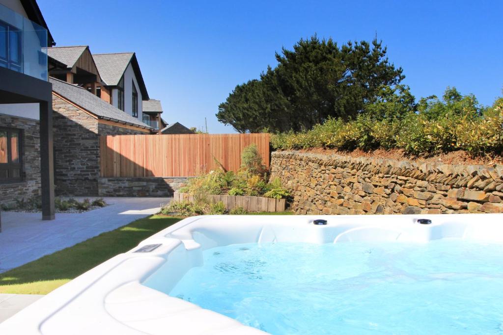 a hot tub in a yard next to a house at Luxury holiday home with HOT TUB in St Merryn