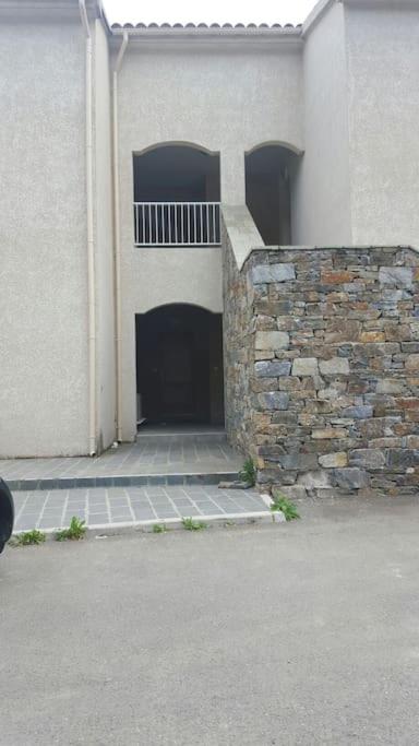a building with a door and a stone wall at Loue studio in Corte