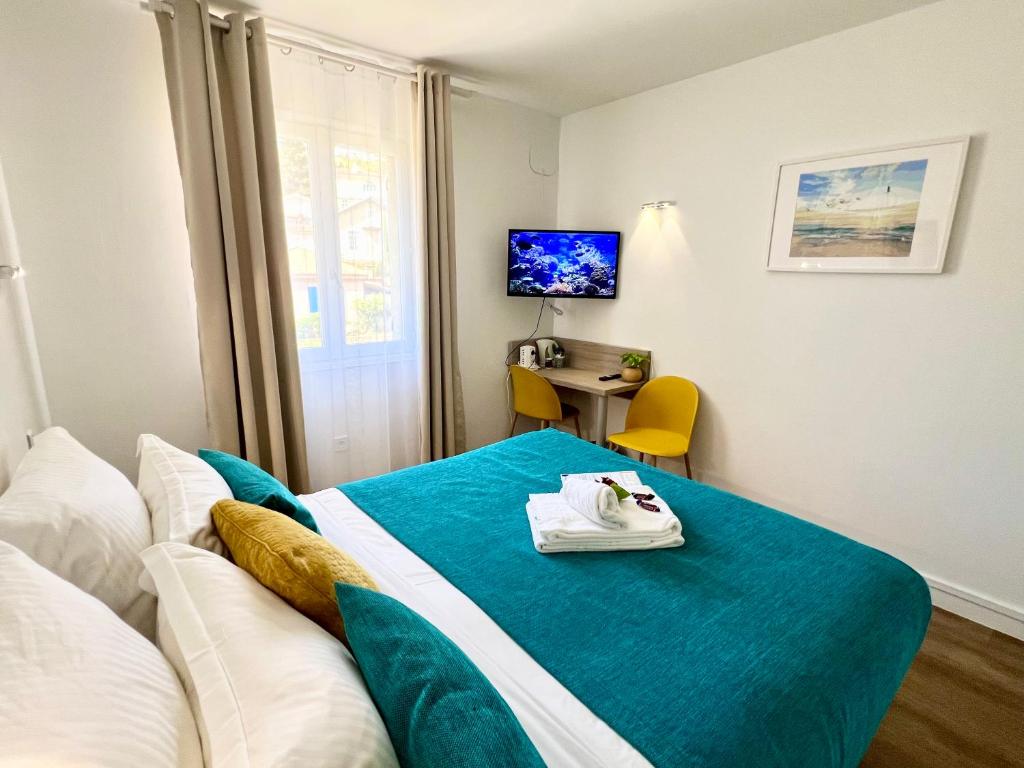 a hotel room with a bed with a towel on it at Hotel L'Escapade in Le Lavandou