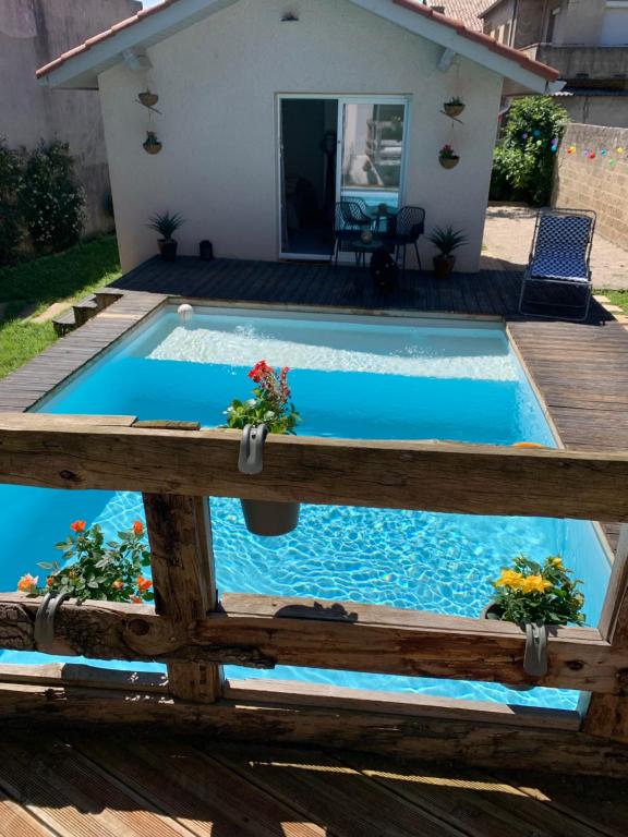 une piscine avec une terrasse en bois et une piscine avec une maison dans l'établissement Le nid, à Bourg-lès-Valence