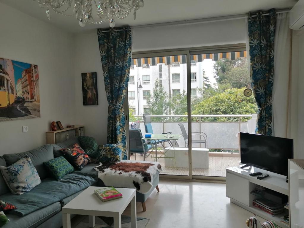 un salon avec un canapé et une grande fenêtre dans l'établissement Résidence Côte d'Azur Cannes, à Cannes