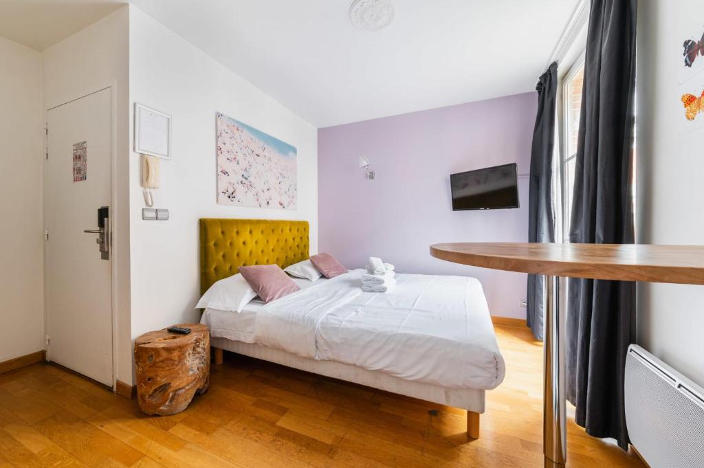 une chambre avec un lit et une table dans l'établissement 204 - Charmant studio jardins des plantes -Paris 5 - FLAT-GUEST, à Paris