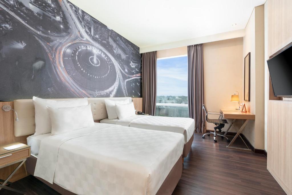 a hotel room with two beds and a tv at Swiss-Belhotel Airport Jakarta in Tangerang