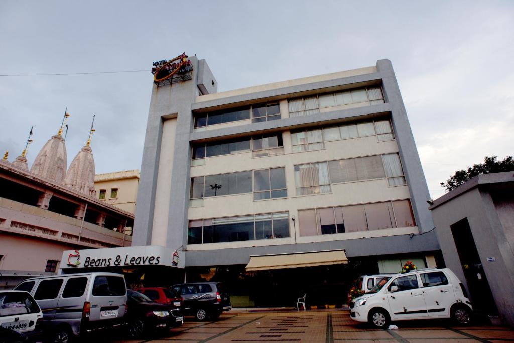 um edifício com carros estacionados em frente em Hotel Platinum Inn em Ahmedabad