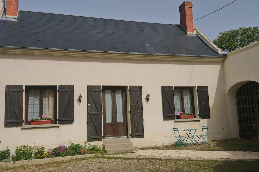 a house with two chairs and a door and windows at Le domaine du Clair Mont entre Beauval et châteaux in Monthou-sur-Cher