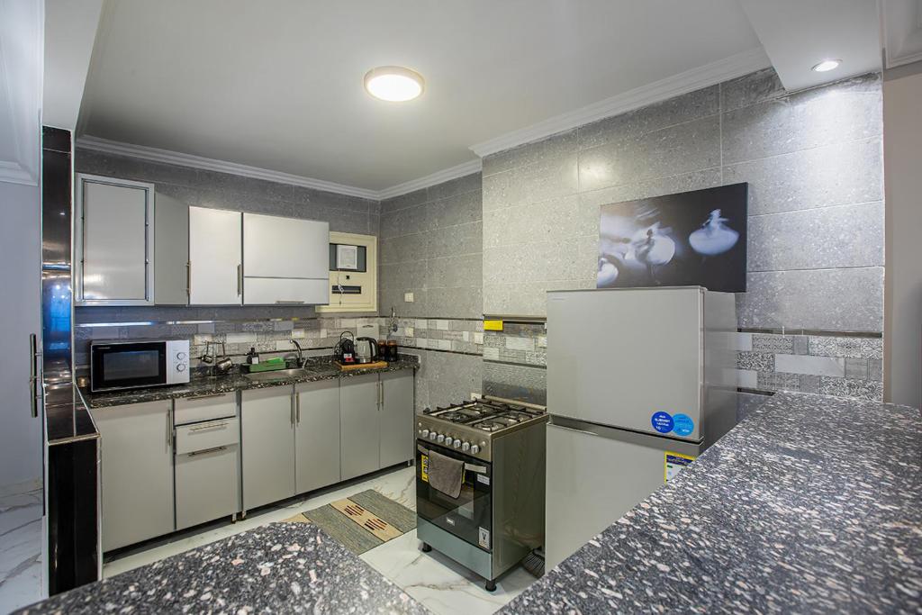 a kitchen with white cabinets and a refrigerator at Skyline Premium Properties in Alexandria